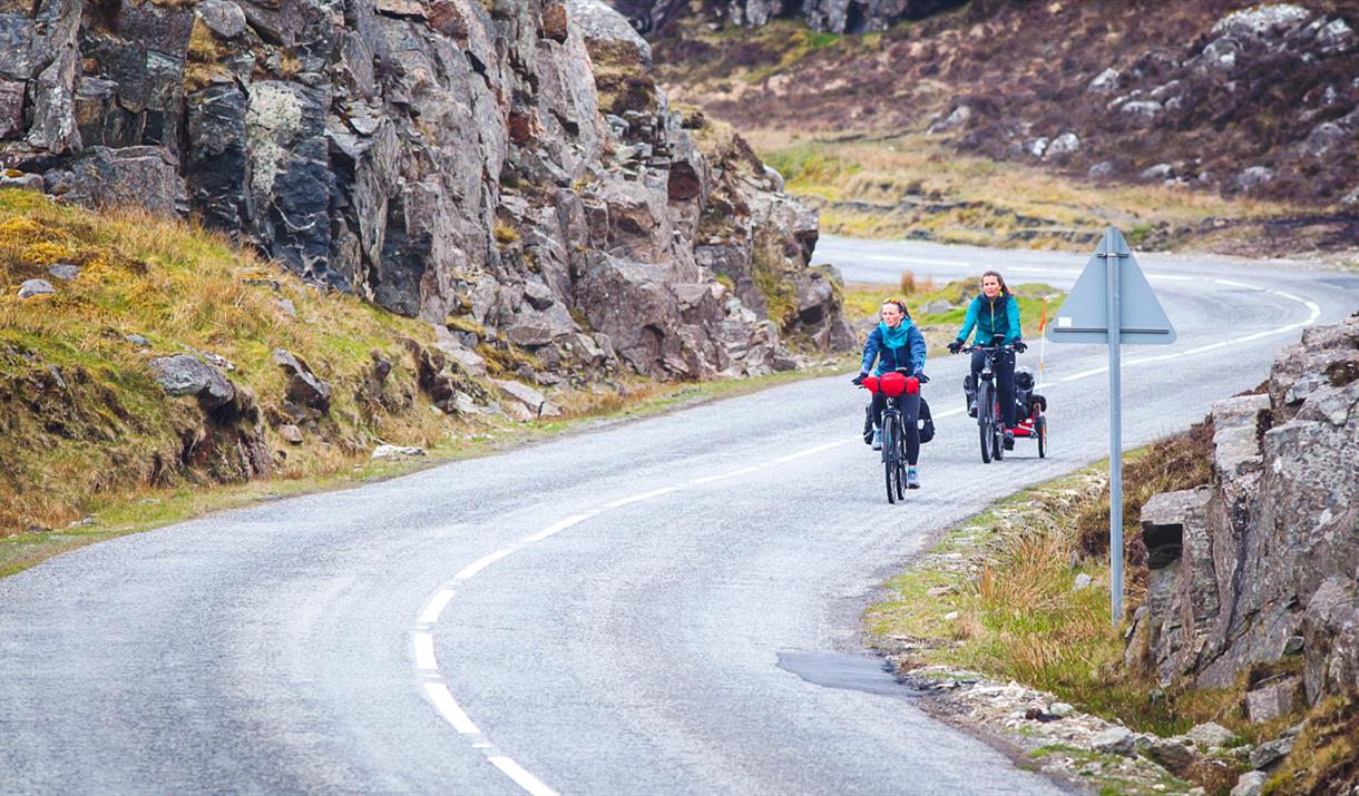 Harris: cyclists on winding double track road