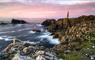 Butt of Lewis lighthouse with a pink sunset sky and long‑exposure Atlantic waves, capturing the rugged Outer Hebrides coastline and classic Lewis and