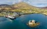 Aerial view of Castlebay, Isle of Barra, featuring a CalMac ferry at the harbour against the backdrop of the island landscape.