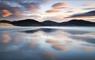 Luskentyre Beach, Isle of Harris, with pink clouds reflecting on wet sand during a long‑exposure shot, capturing soft Atlantic light and classic Outer