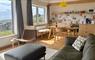 Mangersta Steading Interior a contemporary open plan living/dining/kitchen with a large olive green leather settee and ash wood furniture.