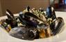 Hebridean mussels in a white bowl with restaurant in background.