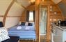 Interior of a Cabin with toilet, ensuite shower room, a double bed and kitchen within curved walls.
